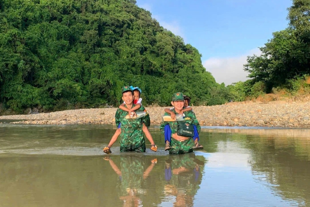 国境警備隊が小川を渡って村に入り、学生たちを開会式に運ぶ - 1 Chiến sĩ biên phòng lội suối vào bản, cõng học sinh đi khai giảng - 1