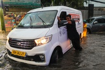 Người dân lội nước đẩy ô tô qua đường ngập sau mưa lớn ở TP Thủ Đức