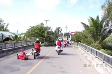 Cô gái bị ngã đau vì ngồi một bên phía sau xe máy