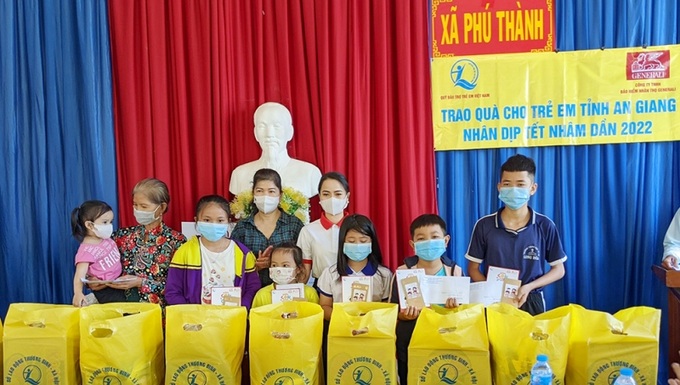 Trẻ em mồ côi nhận phần quà Tết của nhà tài trợ. Ảnh baoangiang.com.vn