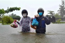 Mưa như trút, lũ dâng mênh mông, dân lội nước ngập ngang lưng về nhà