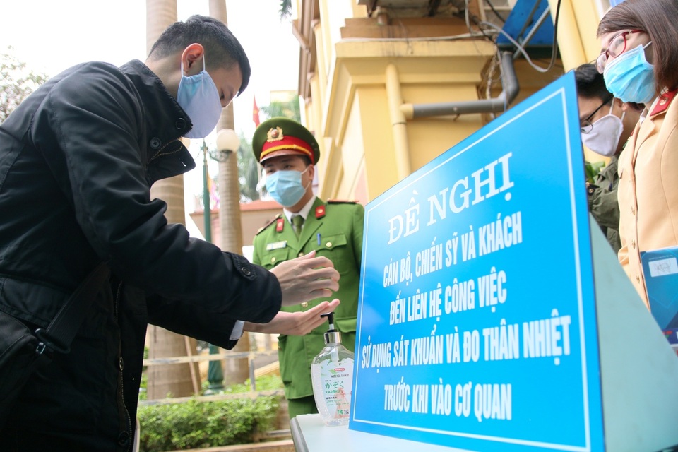 Công an Hà Nội đo thân nhiệt, phát khẩu trang cho công dân đến làm việc - 5