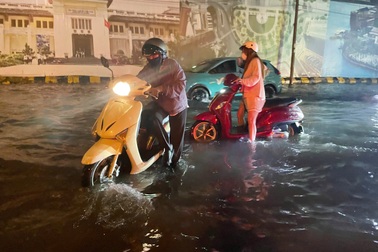 Đường trung tâm TPHCM ngập sau mưa lớn, người dân bì bõm dắt xe
