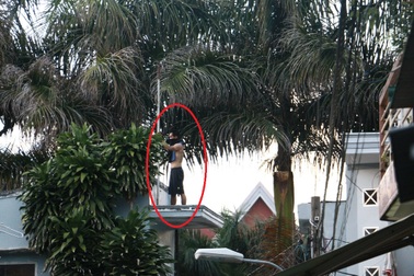 Nam thanh niên bịt mặt cầm hung khí leo trèo trên nóc nhà