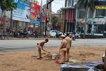 CSGT xúc cát ngăn dầu loang trên quốc lộ