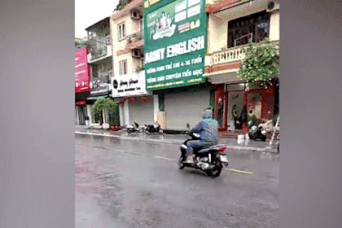 Nhiều người đi xe máy ngã sõng soài do đường đầy dầu mỡ sau mưa lớn