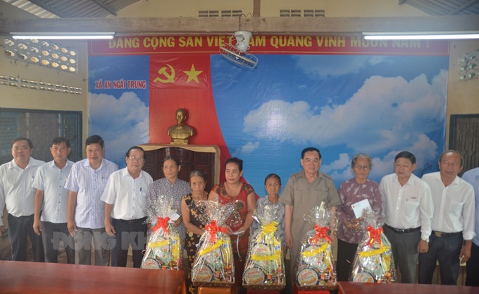 Chủ tịch UBND tỉnh Trần Ngọc Tam (áo nâu) tặng quà cho gia đình có công với cách mạng.