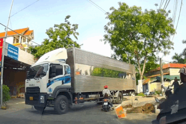 Bất chấp nguy hiểm, người phụ nữ đi xe máy quyết tranh đường với xe tải lớn