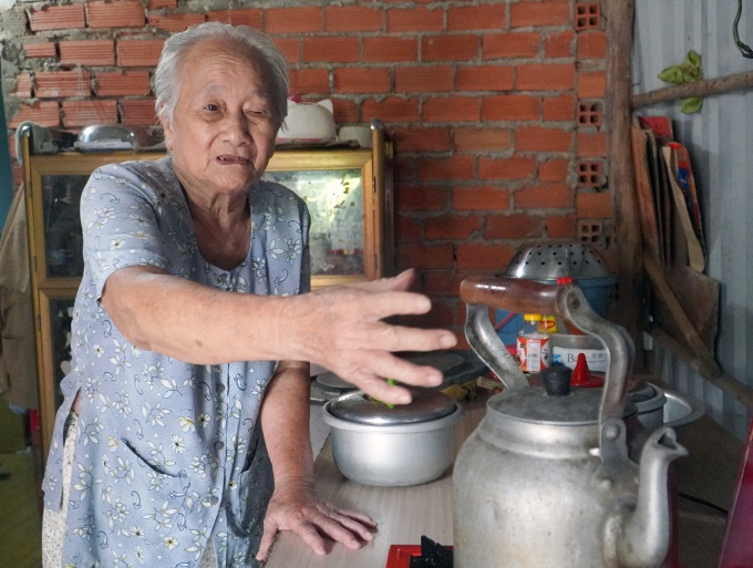 Bà Sáu trong nhà mình ở phường Phú Mỹ, quận 7, TP HCM, chiều 15/8. Từ ngày bị tai biến và Covid-19, đôi mắt bà mờ hẳn, chân tay yếu đi nhiều, mỗi khi muốn đi lại phải nhờ bé Tí Nị dìu. Ảnh: Minh Tâm.