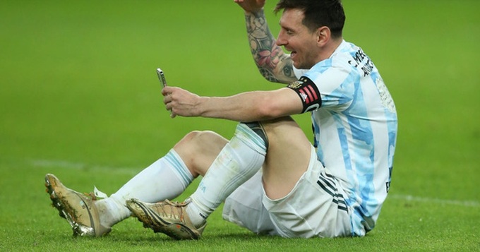 Messi ngồi bệt xuống sân, gọi video khoe huy chương với vợ con