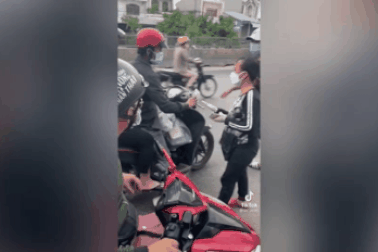 Người phụ nữ đi dép lê phát tiền cho người dân trên đường về quê