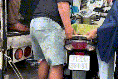 Tài xế lội nước nâng xe lên thùng đưa người dân qua đoạn ngập