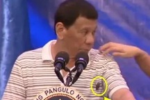 Tổng thống Philippines khi bị gián bò lên người trong lúc phát biểu