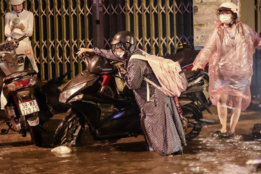 Người dân dắt bộ xe máy về nhà trong cơn mưa lớn tại TPHCM