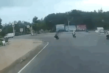 Áo mưa quấn vào bánh xe quật người đi xe máy ngã nhào xuống đường