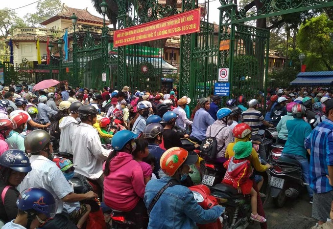 Khu vực cổng Thảo Cầm Viên trên đường Nguyễn Bỉnh Khiêm, người và xe ken cứng, chờ đợi được vào bên trong công viên.