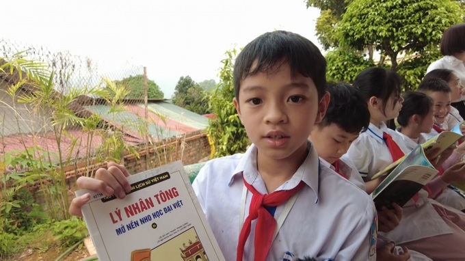 Học sinh thích thú tìm được sách lịch sử yêu thích ở thư viện nhà trường.