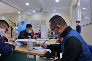 Người dân từ các tỉnh, thành trở lại Hà Nội đội mưa đi khai báo y tế