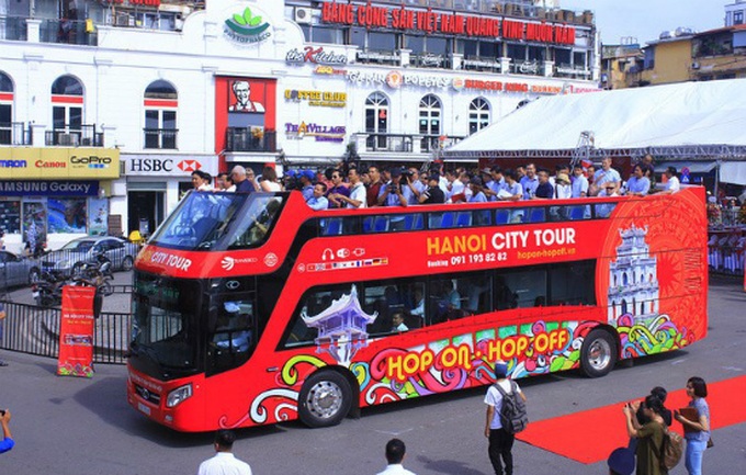Du khách đi xe buýt hai tầng tại Hà Nội.