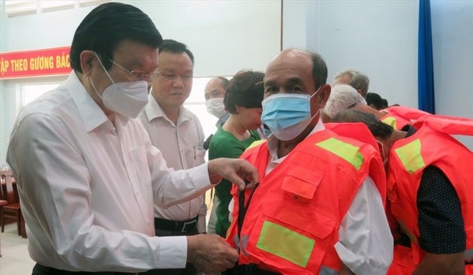 Nguyên Chủ tịch nước Trương Tấn Sang trao áo phao cứu sinh cho ngư dân tỉnh Phú Yên.