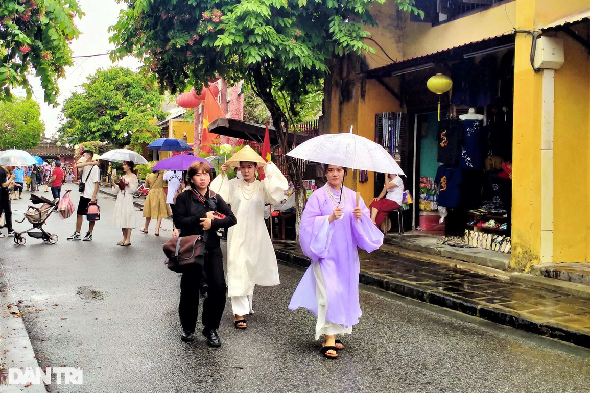 Du khách đội mưa tham quan phố cổ Hội An ngày đầu nghỉ lễ - 6