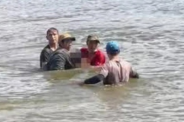 Một nam giới bị trói chân tay, buộc vào tảng đá trôi dạt trên biển