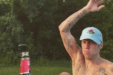 Justin Bieber tham gia thử thách đá bay nắp chai, tranh thủ khoe hình xăm kín người