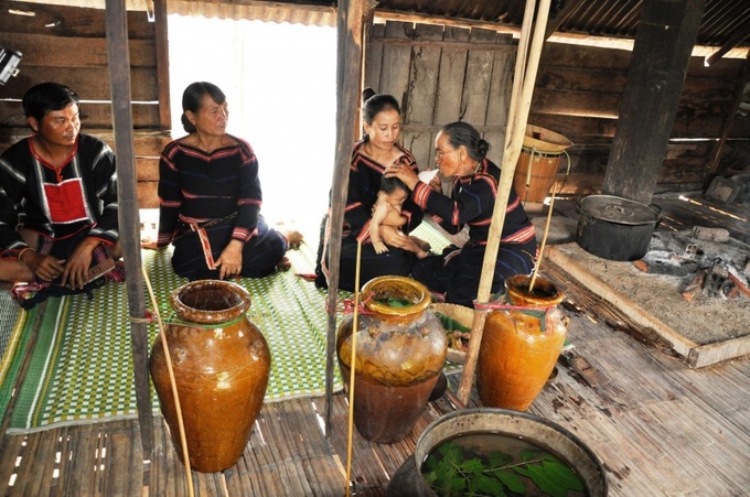 Bà mụ dùng ống nứa thổi tai cho đứa trẻ với những mong ước tốt đẹp.
