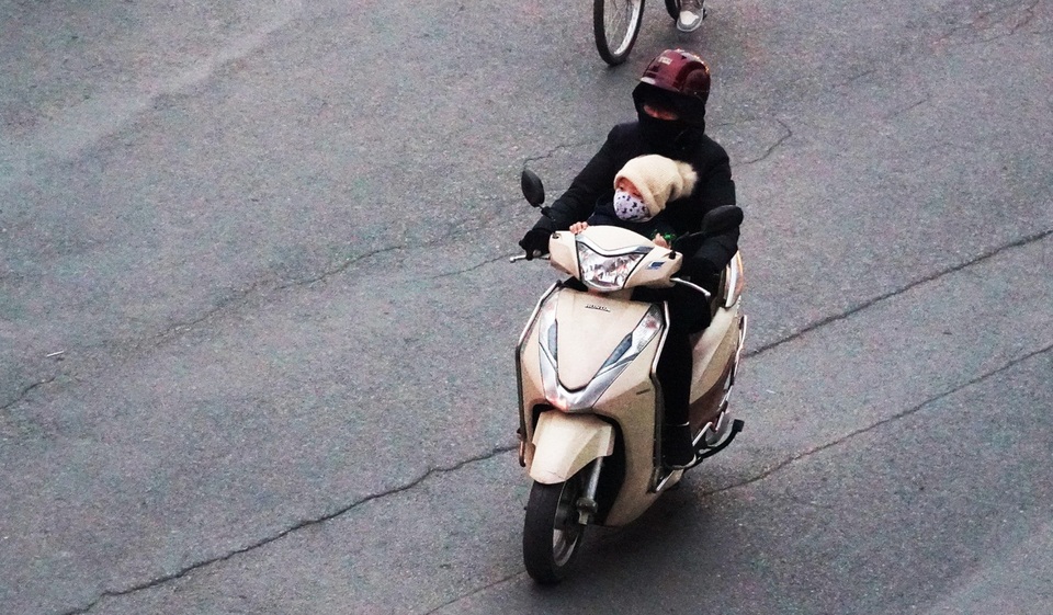 Trẻ em được bố mẹ bọc kín mít đi đường trong tiết trời lạnh giá ở Hà Nội - 4