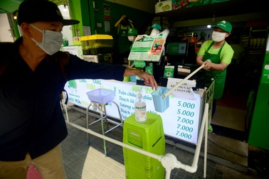 Sợ lây nhiễm, nhân viên quán nước dùng gậy tự chế đưa tiền cho khách