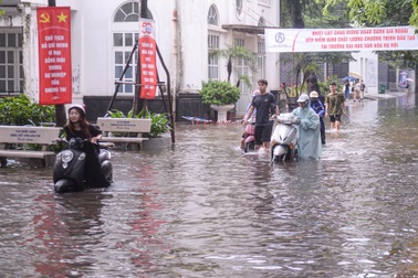 Sân trường đại học ở Hà Nội lênh láng nước, sinh viên bì bõm dắt xe