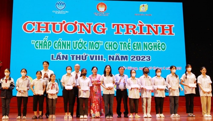 Đại diện Ban tổ chức và nhà tài trợ trao thưởng cho các em học sinh vượt khó học giỏi tại chương trình “Chắp cánh ước mơ”.