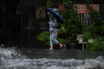 Người dân TPHCM bì bõm lội nước về nhà sau cơn mưa lớn