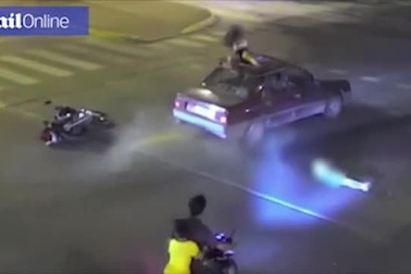 Vượt đèn đỏ, cô gái đi xe máy va chạm và văng lên nóc ô tô