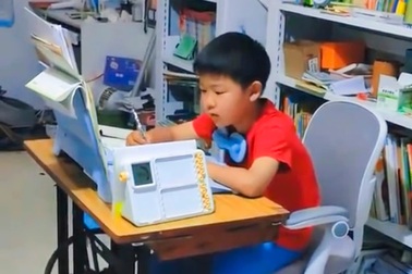 Mẹ cho con trai vừa học, vừa đạp máy may để rèn sự tập trung