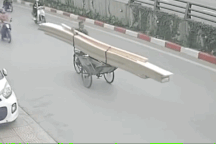 Người phụ nữ đi xe máy lao đầu vào xích lô chở gỗ cồng kềnh giữa đường