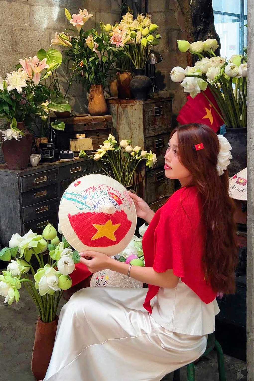 Das Café in Ho-Chi-Minh-Stadt ist farbenfroh mit Flaggen und Blumen und nutzt konische Hutmalerei, um am 2. und 2. September Kunden anzulocken. Quán cà phê ở TPHCM rực rỡ cờ hoa, tung chiêu vẽ nón lá hút khách dịp 2/9 - 2