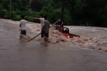 Ô tô bán tải mắc kẹt giữa dòng nước lũ, 2 người may mắn thoát chết