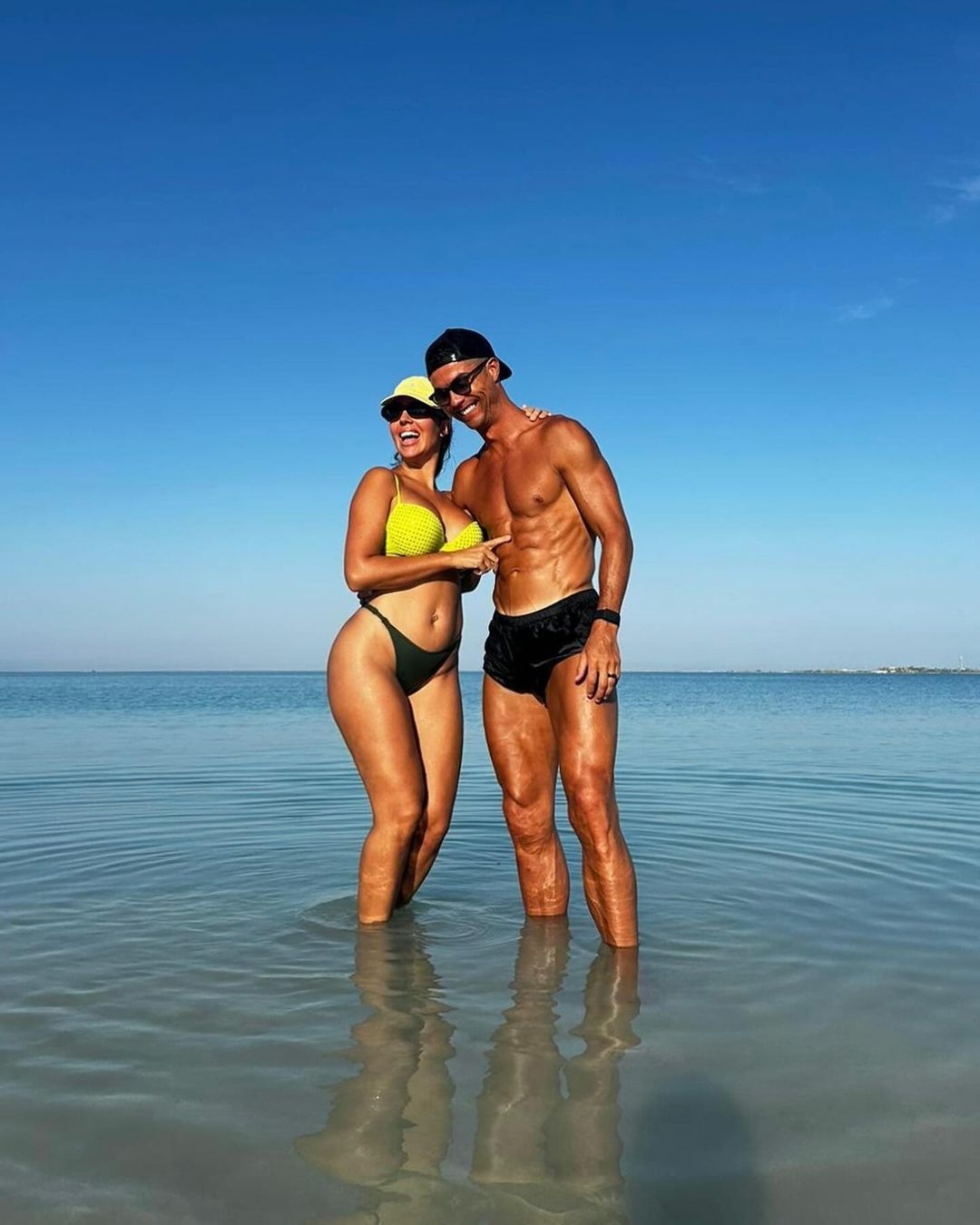 Georgina Rodriguez diện bikini nóng bỏng sánh đôi cùng Cristiano Ronaldo. Siêu mẫu Georgina Rodriguez rực rỡ trong chiếc áo bikini màu xanh nổi bật và chiếc mũ cùng tông. Georgina kết hợp cùng kính râm khi tắm nắng trong chuyến đi nghỉ xa hoa cùng gia đình đến Ả Rập Xê Út. Dù đã trải qua hai lần sinh nở, Georgina Rodriguez vẫn sở hữu thân hình cực hút mắt (Ảnh: Daily Mail).