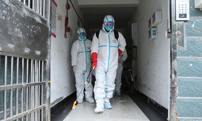 Các nhân viên vệ sinh khử trùng một tòa nhà tại Giang Tây ngày 25/1. Ảnh: AFP.