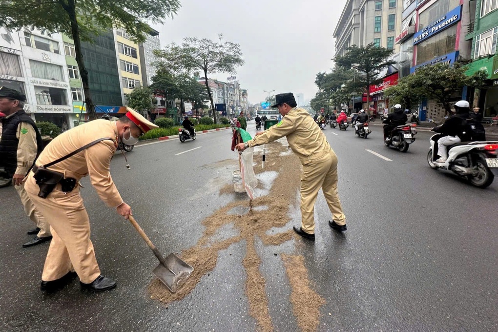 CSGT và công an xử lý vết dầu loang trơn trượt trên đường ở Hà Nội - 1