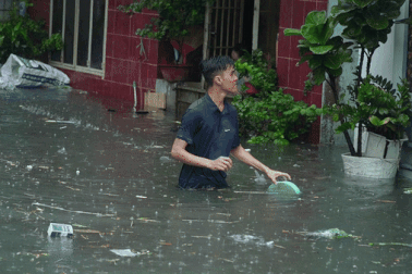 Người dân TPHCM bơm nước ra khỏi nhà sau mưa lớn