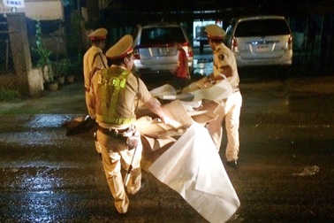 CSGT đội mưa dọn thùng các tông trên đường