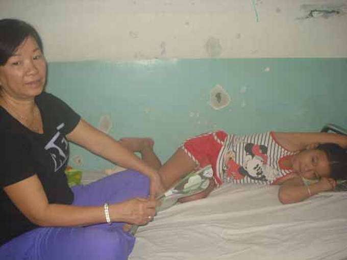 Bệnh nhân Dương Nguyễn Phương Vy đang được bà ngoại chăm sóc tại khoa Nhiễm, Bệnh viện Nhi đồng 2. 