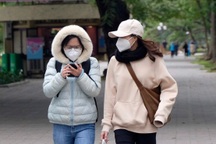 Hà Nội rét đậm, người ra đường phải nép sát nhau, mặc áo mưa tránh gió lạnh