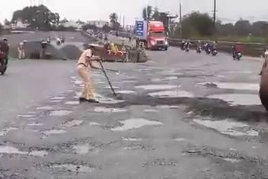 Các chiến sĩ CSGT đẩy xe rùa, dùng cuốc san nền đường cho ô tô lưu thông