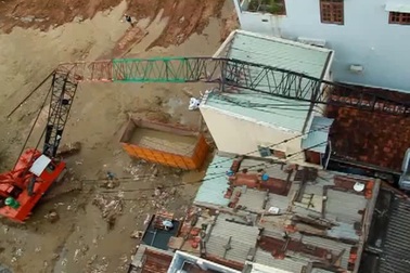 Cần cẩu gãy vắt ngang trên mái nhà dân.