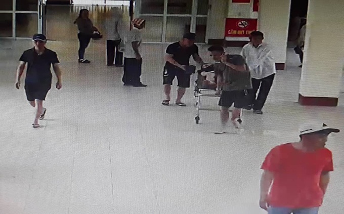 Nhóm người đàn ông đưa thai phụ bị tai nạn giao thông vào làm thủ tục nhập viện. Ảnh: Trích xuất camera