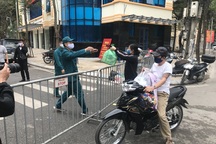 Người dân phố Trúc Bạch nhận nhu yếu phẩm qua hàng rào cách ly