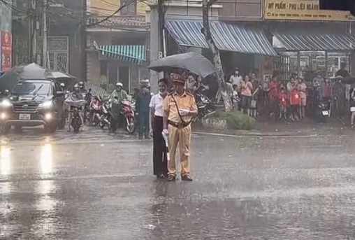 Đại úy CSGT làm nhiệm vụ A80 dưới mưa lớn được người dân che ô - 2
